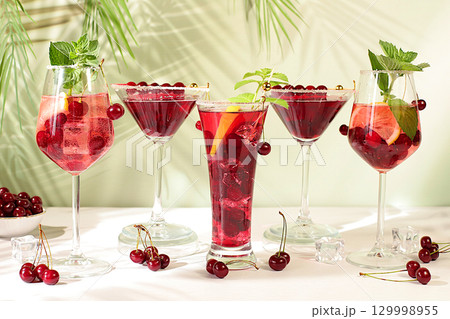 Cherry alcoholic or non-alcoholic cocktails with mint. Martini, mojito and royal sangria with berries, ice, mint and currants. Summer party concept, bar or cafe advertising, detox diet Cherry alcoholic or non-alcoholic cocktails with mint. Martini, mojito and royal sangria with berries, ice, mint and currants. Summer party concept, bar or cafe advertising, detox diet 129998955