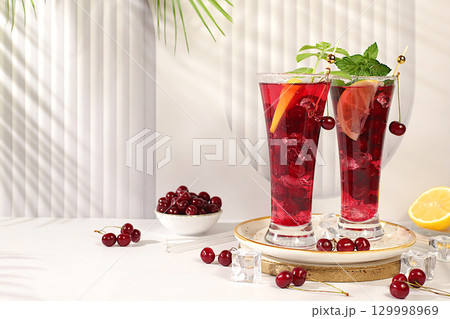 Sangria or cocktail with mint, cherry, soda, lemon and ice, restaurant and bar menu, refreshing summer and autumn drink recipe, detox diet and weight loss concept, Cold homemade lemonade 129998969