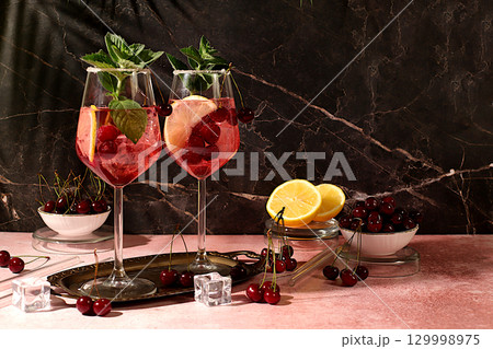 Aperol spritz with cherry, mint, ice with tequila, vodka on elegant background, still life with drinks, minimalist concept for bar, soft and alcoholic drink for weight loss, advertising banner for 129998975