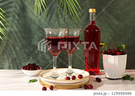 Modern still life with glasses of red wine with cherries and berries. Detox diet and holiday party concept, autumn vitamin drinks, advertising banner for bar or restaurant, photo menu. Modern still life with glasses of red wine with cherries and berries. Detox diet and holiday party concept, autumn vitamin drinks, advertising banner for bar or restaurant, photo menu. 129998986