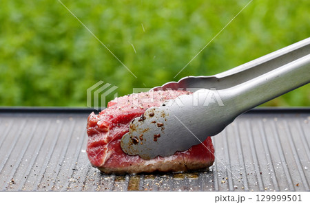 cook preparing fresh raw beef fillet mignon steak 129999501