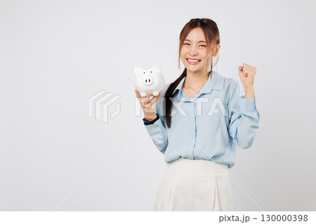 Smiling happy woman excited to save money with piggy bank and piggy win, symbol of finance success savings and smart personal investment. isolated studio white background 130000398