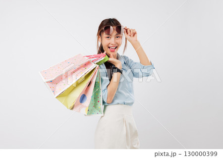 Happy asian woman excited shopping, Take off sunglasses posing with a bag, looking surprised and cheerful while holding her shopping bags, proud of each bag, isolated studio white background 130000399