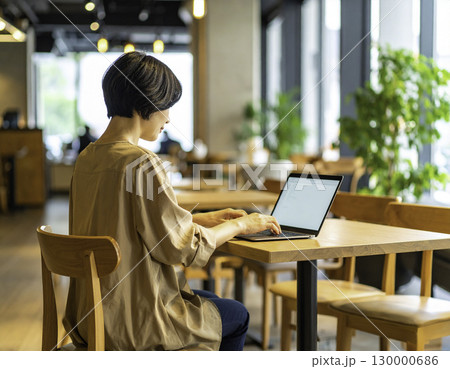 カフェでノートパソコンを使う女性の後ろ姿 130000686