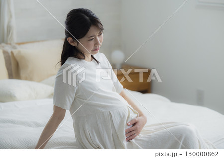 寝室でベッドに座る妊婦 130000862