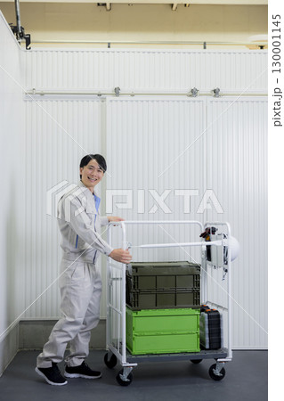 倉庫で台車を押す作業着の男性 倉庫で台車を押す作業着の男性 130001145