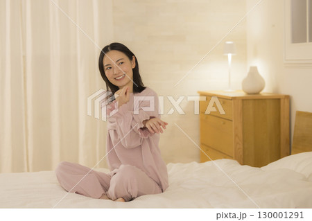 ベッドに座る女性 130001291