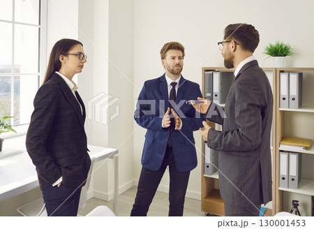 Team of young business people having a discussion on a serious topic at a work meeting 130001453