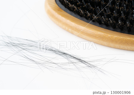 白背景に豚毛のヘアブラシと抜けた髪の毛のクローズアップ 白背景に豚毛のヘアブラシと抜けた髪の毛のクローズアップ 130001906