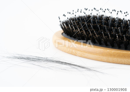 白背景に豚毛のヘアブラシと抜けた髪の毛のクローズアップ 130001908