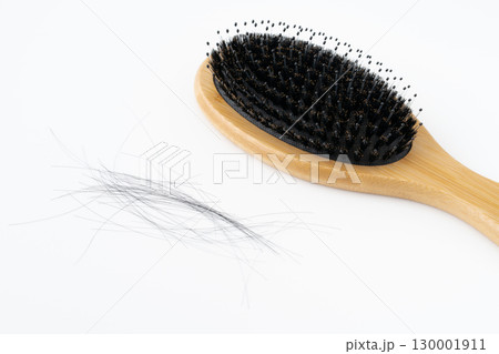 白背景に豚毛のヘアブラシと抜けた髪の毛のクローズアップ 130001911