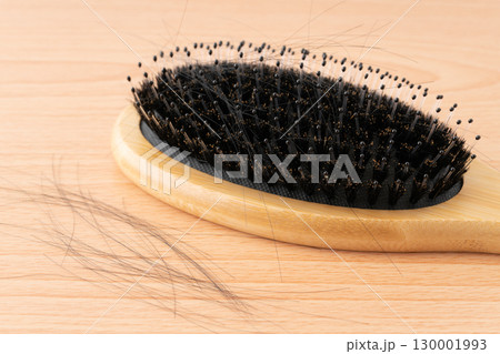 豚毛のヘアブラシと抜けた髪の毛のクローズアップ 130001993