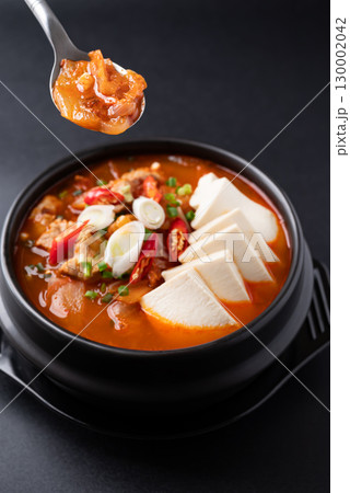 Korean food (Kimchi Jjigae), Kimchi soup with tofu and pork in Korean stone bowl  130002042
