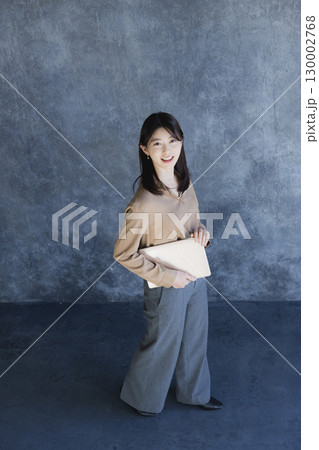 ノートパソコンを持って立っている女性  ノートパソコンを持って立っている女性  130002768