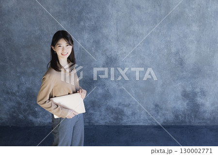 ノートパソコンを持って立っている女性　 130002771