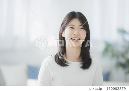 部屋でコーヒーを飲む若い女性 130002879