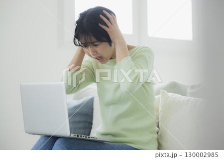 パソコンの前で頭を抱える女性 130002985