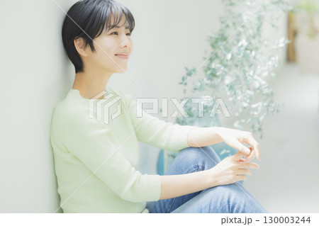 壁にもたれている若い女性 壁にもたれている若い女性 130003244