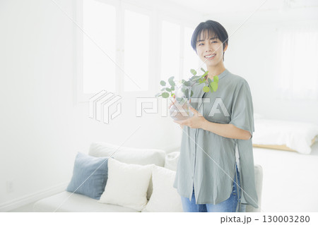 観葉植物に水やりをする女性 130003280