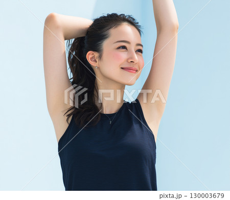 爽やかにストレッチする20代日本人女性の屋外ポートレート（フィットネス 美容 宣材） 130003679