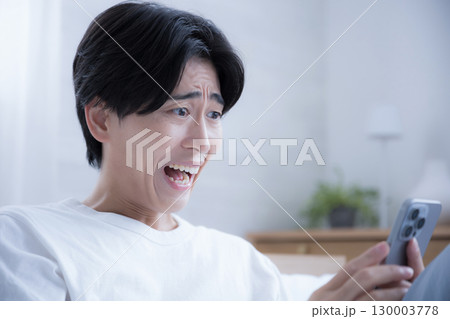 スマホを持って驚く困るビックリする人 スマホを持って驚く困るビックリする人 130003778