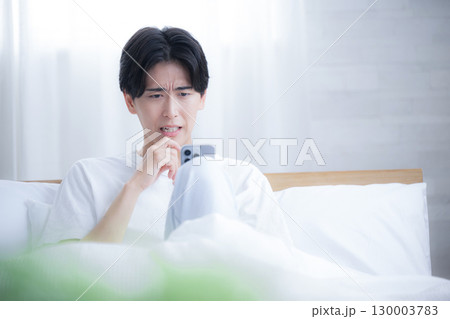 スマホを持って驚く困るビックリする人 130003783