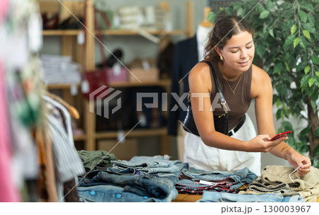 Woman scans pants on phone in store 130003967