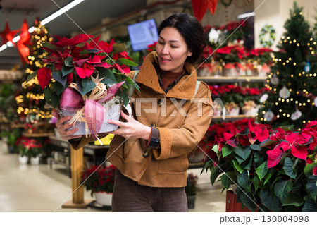 Woman shopping in home plant store in christmas time Woman shopping in home plant store in christmas time 130004098