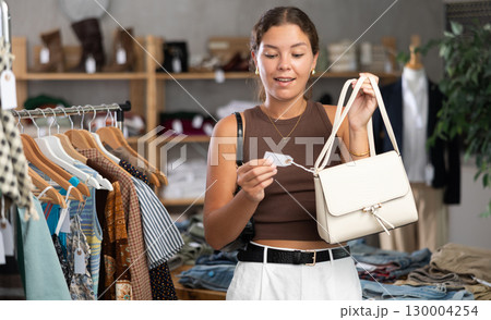 Woman choosing handbags in the store Woman choosing handbags in the store 130004254