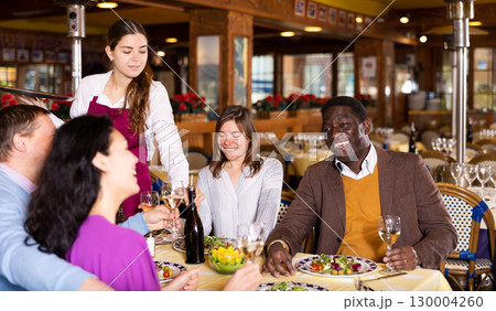 Couple on friendly meeting over dinner with wine in restaurant 130004260