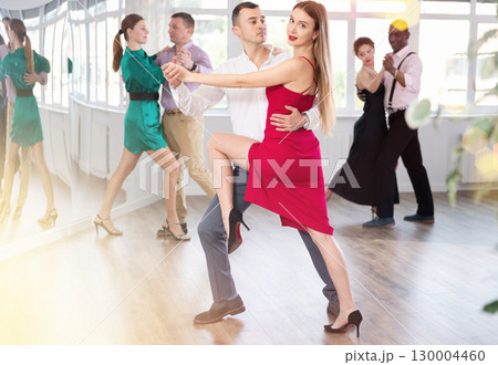 Woman dances incendiary tango with man partner during choreography lesson Woman dances incendiary tango with man partner during choreography lesson 130004460