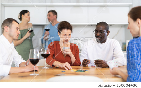 Friends who enjoy lively game of poker and pleasure of tasting fine wine in comfort of their own home Friends who enjoy lively game of poker and pleasure of tasting fine wine in comfort of their own home 130004480