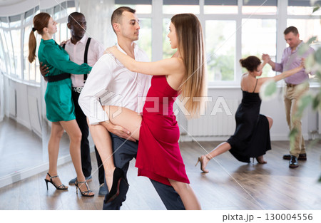 Woman dances incendiary tango with man partner during choreography lesson Woman dances incendiary tango with man partner during choreography lesson 130004556