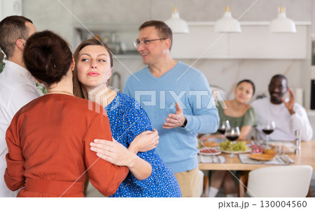 Married couples meet at home for festive dinner. Greet each other 130004560