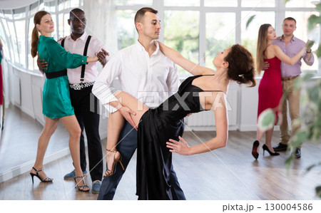 Passionate man and woman practicing tango in dancing studio 130004586