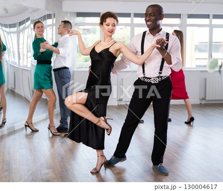 Middle-aged man and woman practicing waltz in dancing studio 130004617