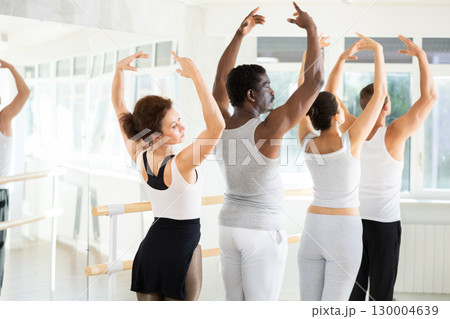 Group of dancers stand in first position at barre Group of dancers stand in first position at barre 130004639