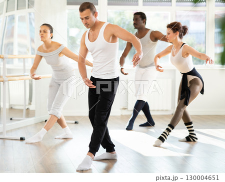 Motivated young adult man participating in group ballet class Motivated young adult man participating in group ballet class 130004651
