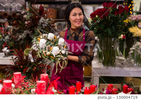 Woman in apron in christmas goods store 130004719