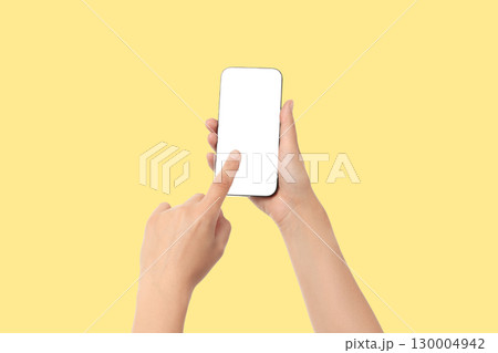 A person points at a blank smartphone screen in bright yellow A person points at a blank smartphone screen in bright yellow 130004942