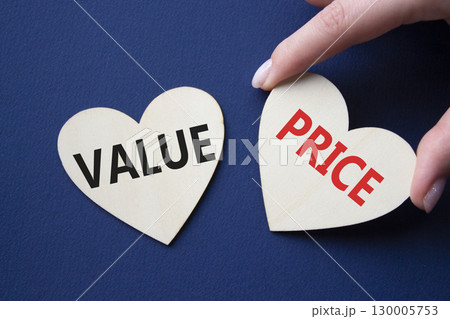 Price and Value symbol. Concept word Price and Value on wooden hearts. Businessman hand. Beautiful deep blue background. Business and Price and Value concept. Copy space 130005753