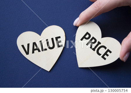 Price and Value symbol. Concept word Price and Value on wooden hearts. Businessman hand. Beautiful deep blue background. Business and Price and Value concept. Copy space 130005754