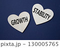 Growth and Stability symbol. Concept word Growth and Stability on wooden hearts. Beautiful deep blue background. Business and Growth and Stability concept. Copy space 130005765