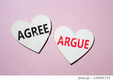Agree or Argue symbol. Concept word Agree or Argue on wooden hearts. Beautiful pink background. Business and Agree or Argue concept. Copy space 130005774