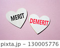 Merit or Demerit symbol. Concept word Merit or Demerit on wooden hearts. Beautiful pink background. Business and Merit or Demerit concept. Copy space 130005776
