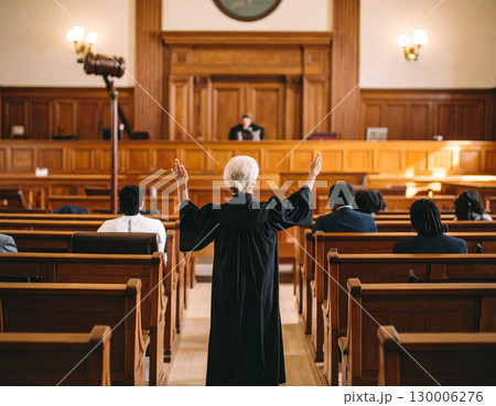 AI generated A judge stands at the edge of the frame gesturing to enter the courtroom with a serious expression. The background shows a formal trial setting with wooden benches 130006276