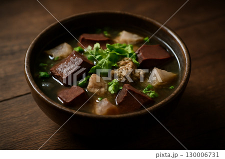 AI generated vibrant image of Thai pork blood soup served in a rustic wooden bowl. The rich textures and earthy tones emphasize the authenticity and warmth of traditional Thai cuisine. 130006731