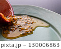 皿の上の半分に切ったパッションフルーツからこぼれ出る果実と果汁 130006863