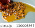 皿の上の半分に切ったパッションフルーツからこぼれ出る果実と果汁 130006865