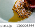 皿の上の半分に切ったパッションフルーツからこぼれ出る果実と果汁 130006866